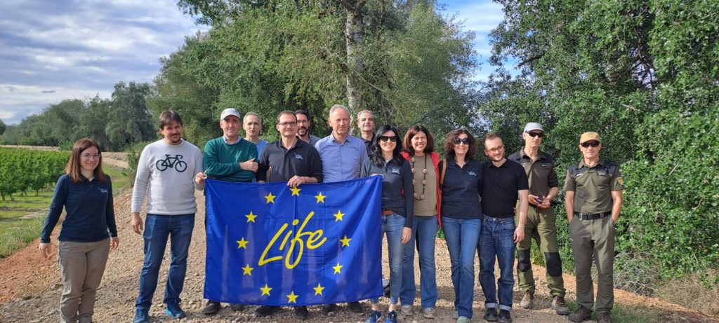 Grupo con bandera en la visita al Soto Aguilar, en Fuentes de Ebro, durante la visita del monitor del programa LIFE