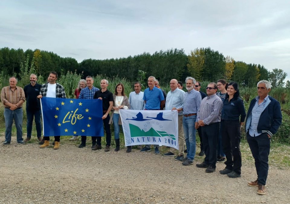 Grupo de representantes de Ayuntamientos y sindicatos navarros con la bandera LIFE en la visita a las áreas de inundabilidad de Aragón para conocer estas intervenciones.