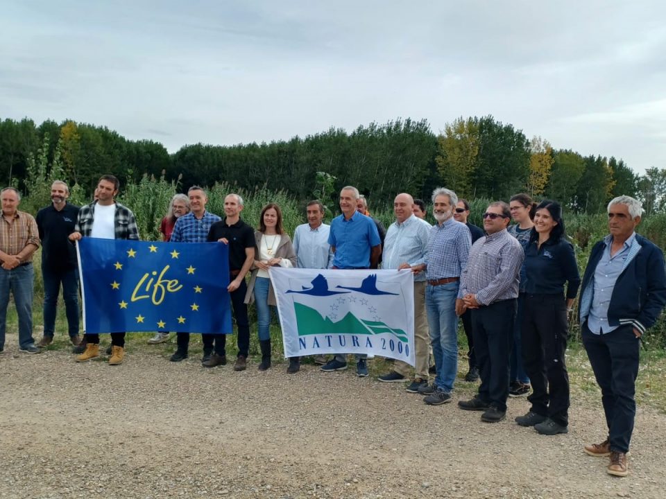 Grupo de representantes de Ayuntamientos y sindicatos navarros con la bandera LIFE en la visita a las áreas de inundabilidad de Aragón para conocer estas intervenciones.